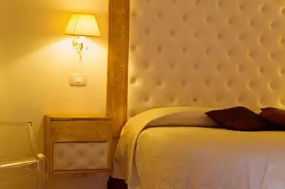 a bedroom with a bed with a headboard and a lamp at Caput Mundi Suite in Rome