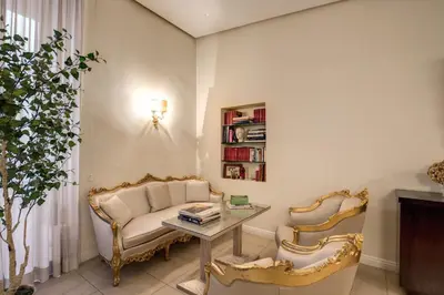 a living room with two chairs and a table at Caput Mundi Suite in Rome