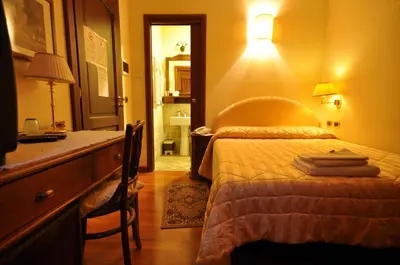 a bedroom with a bed and a dresser with a lamp at Casale De Santis in Rome