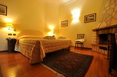 a bedroom with a large bed and a fireplace at Casale De Santis in Rome