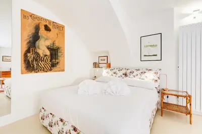 a white bed in a room with a poster on the wall at Al Portico 39 apartment with terrace in Rome
