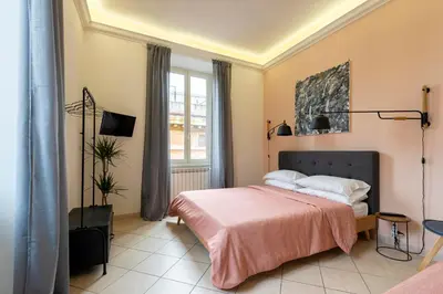 a bedroom with a bed with a pink blanket at Redseven Rome Apartments in Rome
