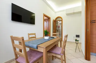 a dining room with a table and chairs and a television at Redseven Rome Apartments in Rome