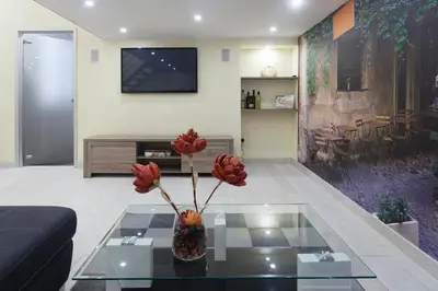 a living room with a vase with flowers on a glass table at Trastevere Charming Loft in Rome