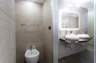 a bathroom with a sink and a toilet and a mirror at Trastevere Charming Loft in Rome