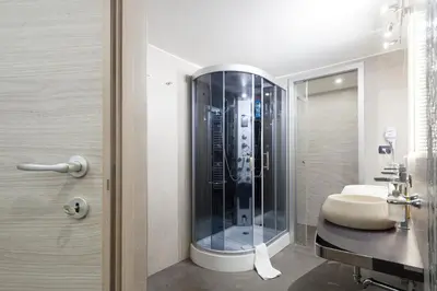 a bathroom with a glass shower and a sink at Trastevere Charming Loft in Rome