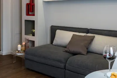 a living room with a couch and a glass of wine at Z-ArchSuites in Rome