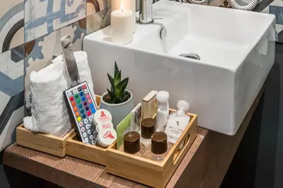 a bathroom sink with a wooden tray with toiletries at Z-ArchSuites in Rome