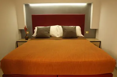 a bedroom with a large bed with an orange blanket at All Seasons in Rome