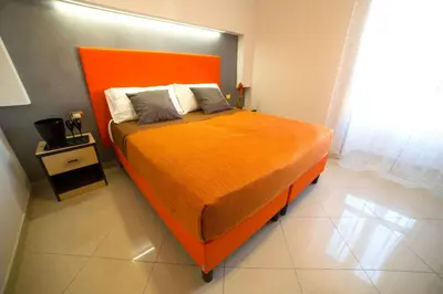 an orange bed in a room with a window at All Seasons in Rome