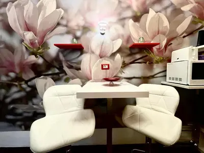 a table and chairs in front of a flower wall at Rhome86 in Rome