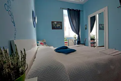 a bedroom with a large bed with blue walls at Rhome86 in Rome