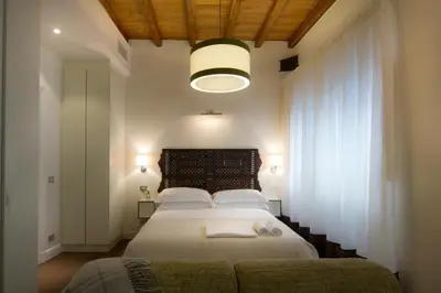 a bedroom with a large bed with white sheets at La Gensola In Trastevere in Rome