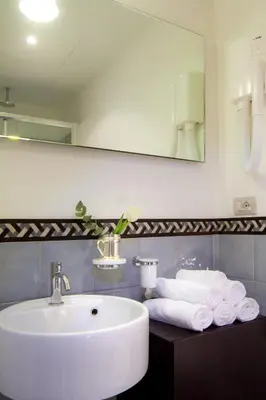 a bathroom with a sink and a mirror and towels at La Gensola In Trastevere in Rome