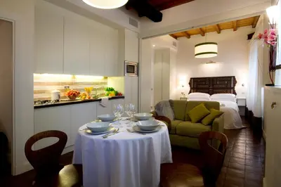 a kitchen and a living room with a table in a room at La Gensola In Trastevere in Rome
