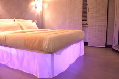 a bedroom with a bed with pink lights on it at Tiburtina House in Rome