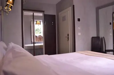 a bedroom with a large white bed and a mirror at Tiburtina House in Rome
