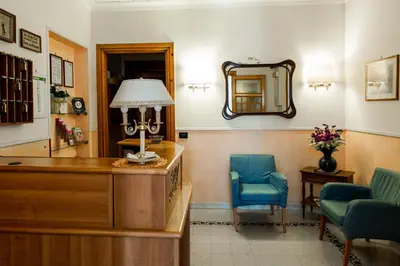 a room with a desk and a chair and a mirror at Hotel Ascot in Rome