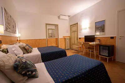 a hotel room with two beds and a television at Hotel Ascot in Rome