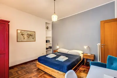 a bedroom with a bed and a blue chair at ilPlatano-Testaccio in Rome