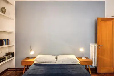 a bedroom with a bed with two nightstands and two lamps at ilPlatano-Testaccio in Rome