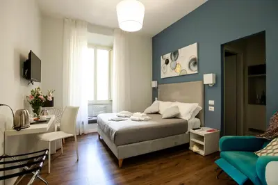 a bedroom with a bed and a blue wall at Eighty Four Rooms in Rome