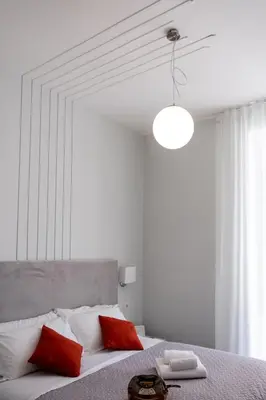a white bedroom with a bed with red pillows at Eighty Four Rooms in Rome