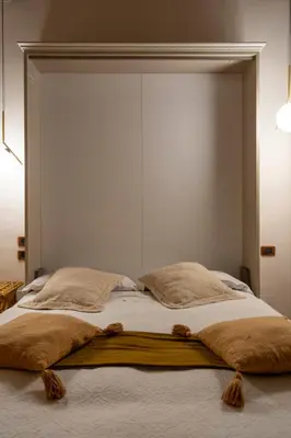a large bed with a large headboard in a bedroom at Condotti Rooms in Rome