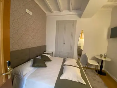 a bedroom with a large bed and a table at Condotti Rooms in Rome