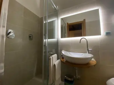 a bathroom with a sink and a shower with a mirror at Condotti Rooms in Rome