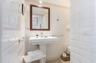 a white bathroom with a sink and a mirror at The Bluehostel in Rome