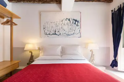 a bedroom with a red bed with two lamps at The Bluehostel in Rome