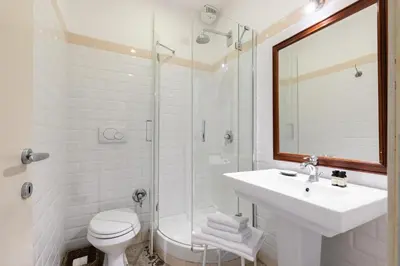 a white bathroom with a sink and a shower at The Bluehostel in Rome