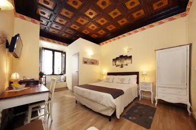 a bedroom with a bed and a desk and a desk at Tibullo Guesthouse in Rome