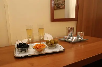 a tray of fruit and wine glasses on a table at Tibullo Guesthouse in Rome