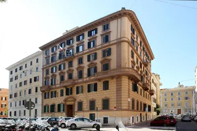 a large building with cars parked in a parking lot at Tibullo Guesthouse in Rome