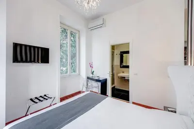 a white bedroom with a bed and a bathroom at Imperia Suite in Rome