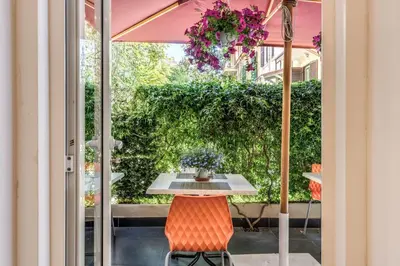 a table and chairs on a patio with an umbrella at Imperia Suite in Rome