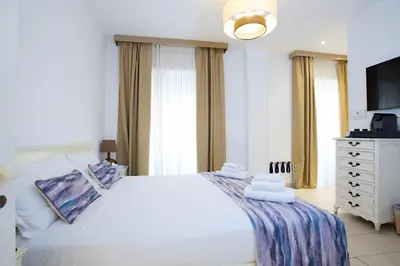 a bedroom with a large white bed and a television at St. Peter' Six Rooms & Suites in Rome