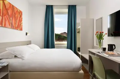 a bedroom with a bed and a desk and a window at Colosseo Panorama by GHOR in Rome