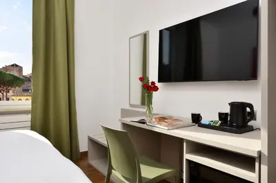 a bedroom with a desk with a tv and a bed at Colosseo Panorama by GHOR in Rome