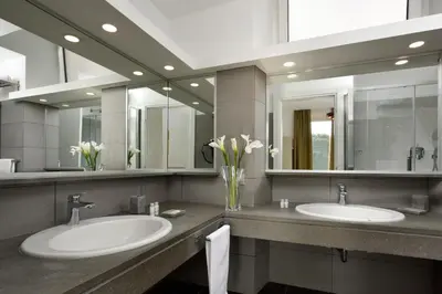 a bathroom with two sinks and two mirrors at Colosseo Panorama by GHOR in Rome