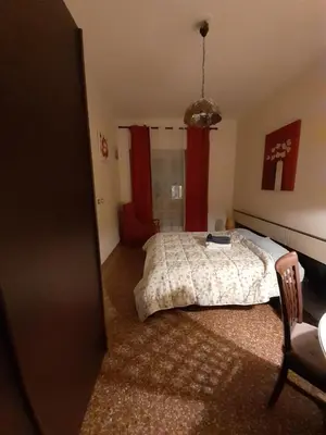 a bedroom with a bed and a red window at Liudan&rooms Affittacamere in Rome