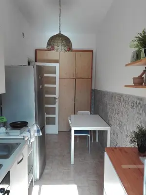 a kitchen with a table and a refrigerator at Liudan&rooms Affittacamere in Rome