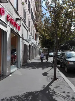 a person walking down a sidewalk next to a building at Liudan&rooms Affittacamere in Rome