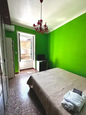 a green bedroom with a bed with a green wall at Liudan&rooms Affittacamere in Rome