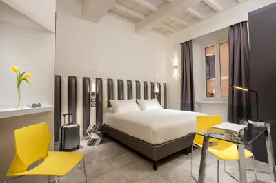 a hotel room with a bed and yellow chairs at GCF Luxury Suites, Guest house in Rome