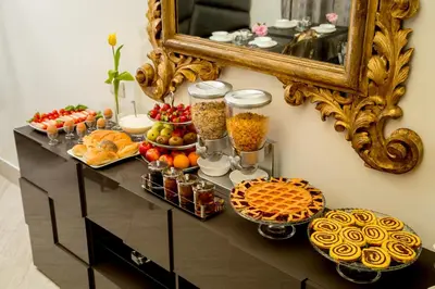 a buffet of food on a table in front of a mirror at GCF Luxury Suites, Guest house in Rome