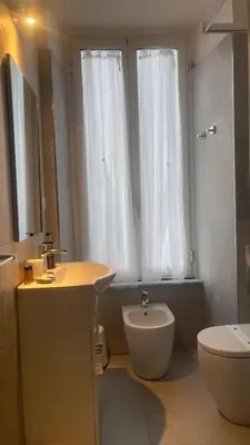 a bathroom with a sink and a toilet and a window at Suitedream Vatican in Rome