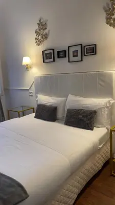 a large white bed with two pillows on it at Suitedream Vatican in Rome
